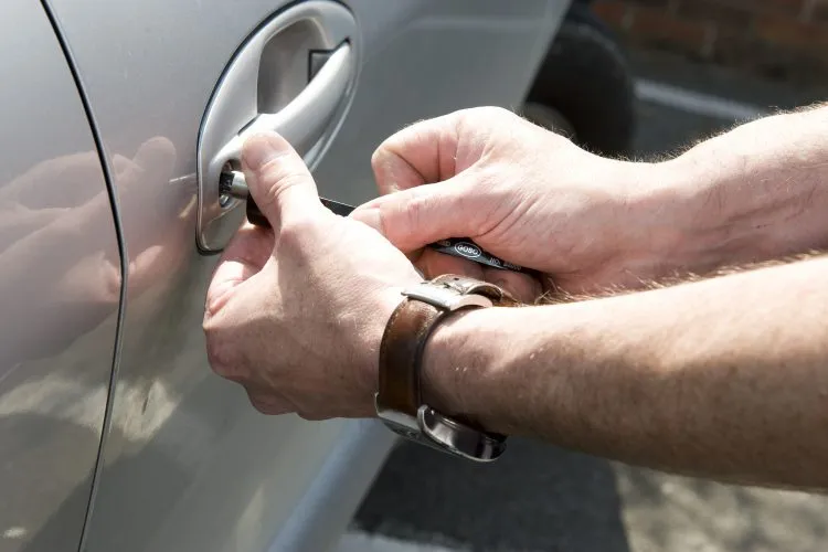 Locksmith opening a car door using professional tools